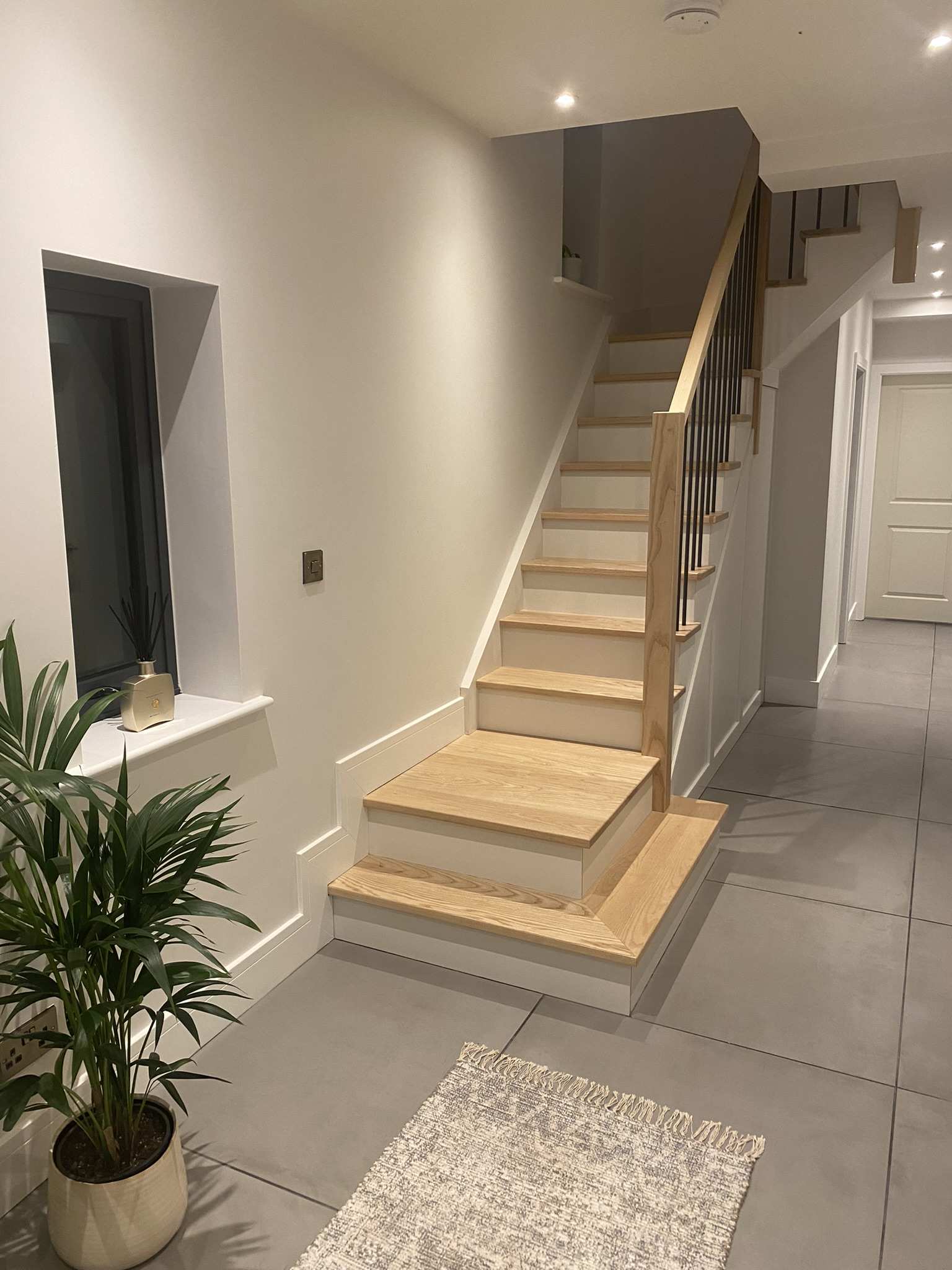 Bespoke clad staircase with hardwood handrail and glass balustrade